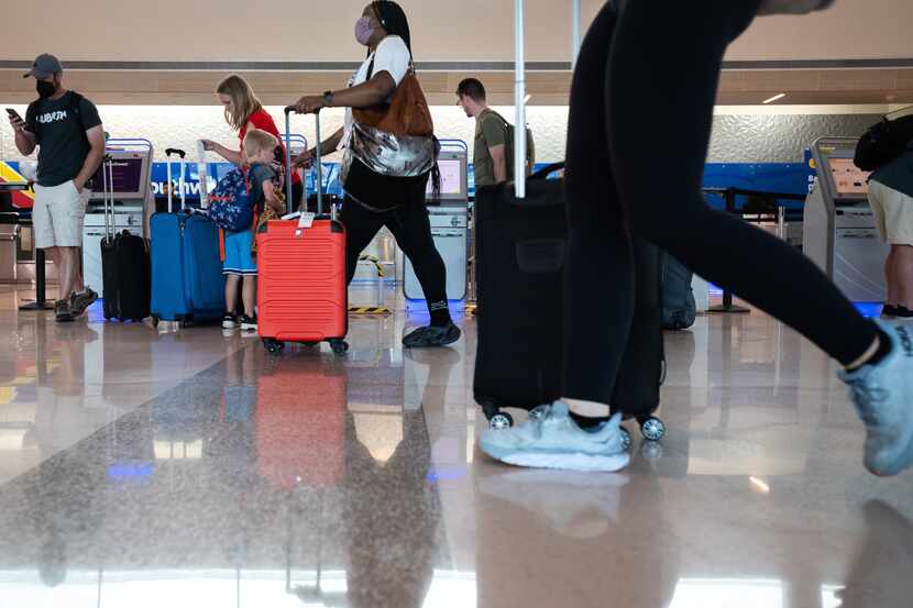 Travelers walk toward security and baggage counters at Dallas Love Field on Wednesday to...