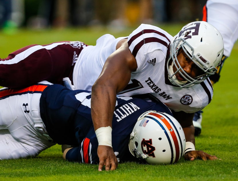 Auburn quarterback Sean White  is sacked by Texas A&M defensive lineman Myles Garretton...