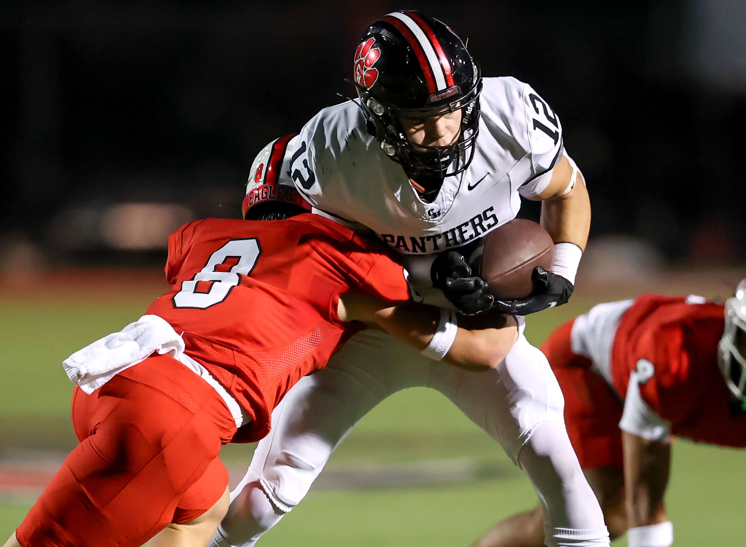 Colleyville Heritage wide receiver Dax Hebeisen (12) gets wrapped up by Argyle defensive...