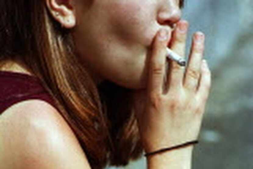 En una foto de archivo del 2000, una jovencita de 15 años de edad fuma frente a su escuela...