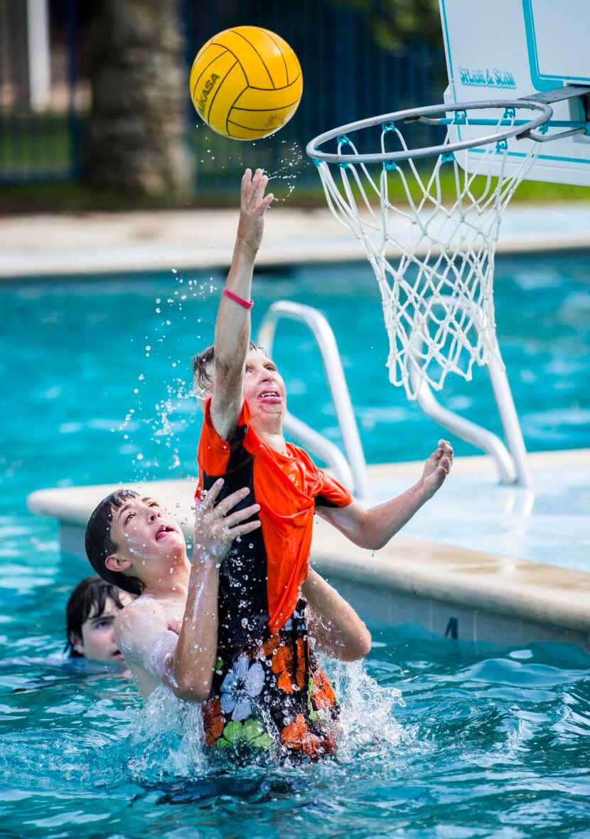 Clay Fite,  11, gets some help from Billy Clay, 13, while playing water basketball. Camp...