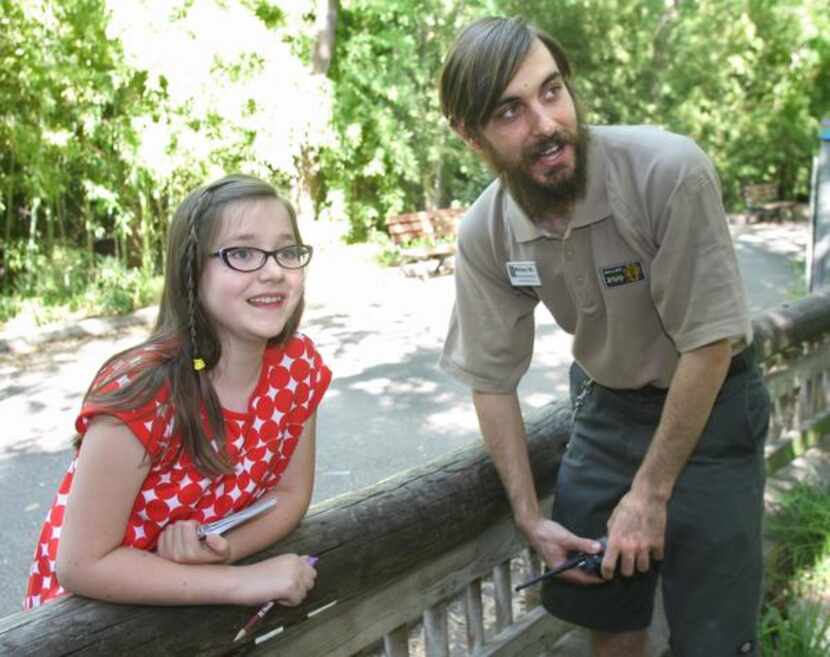 KATIE DAMM , 9, interviews primate keeper Mikey Marazzi in front of the titi monkey...