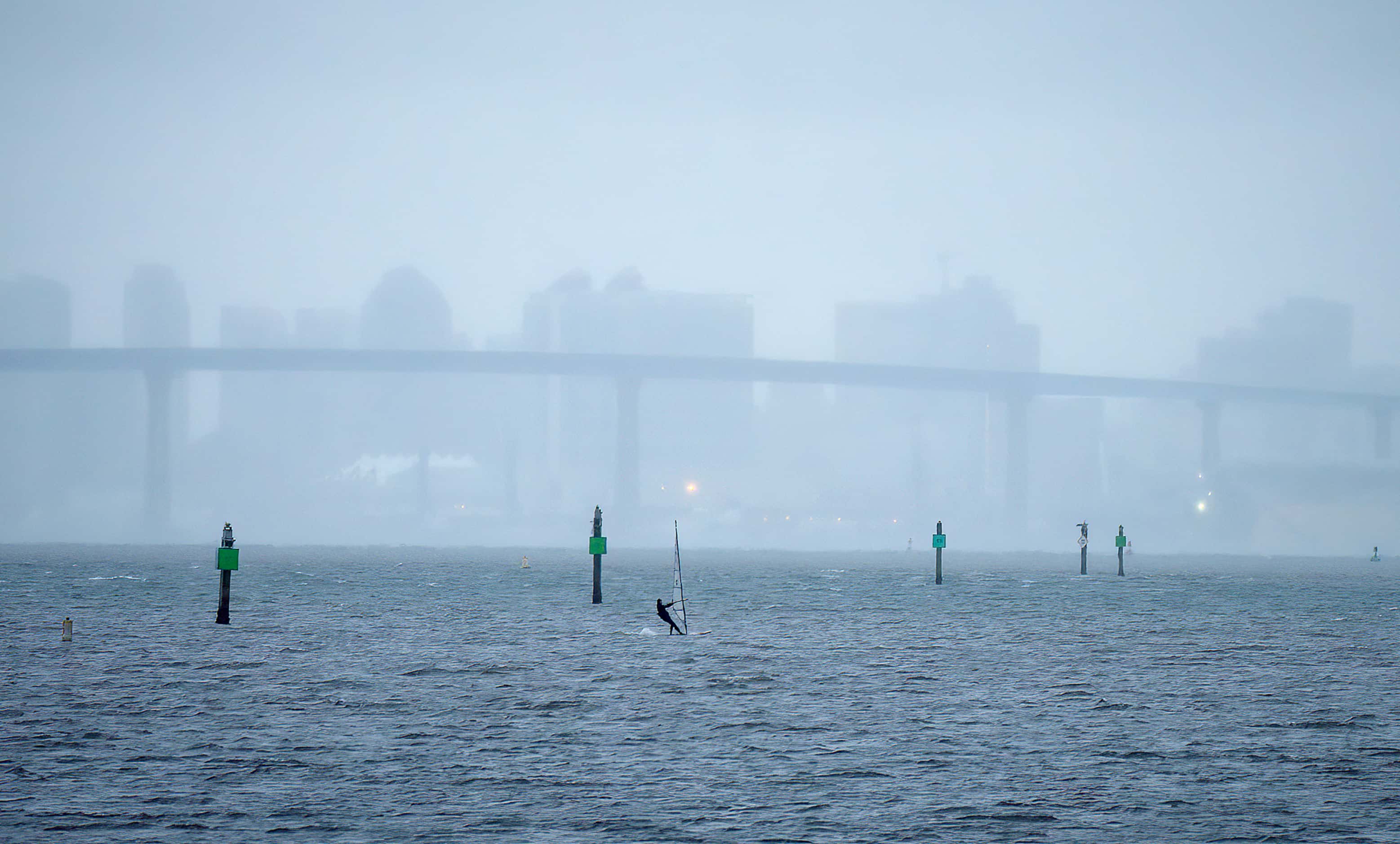 A lone windsurfer, backdropped by the San Diego skyline, takes advantage of the high winds...