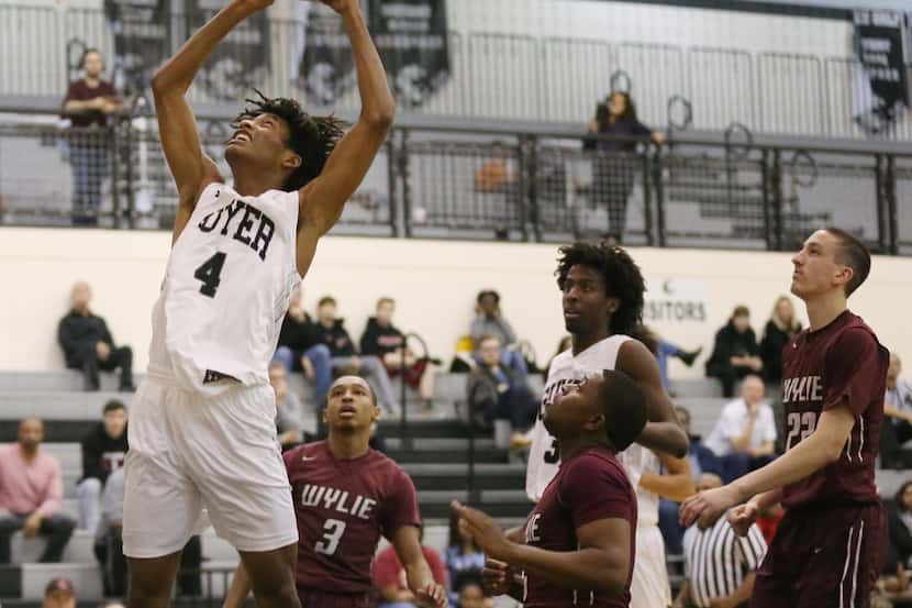 Guyer guard Chris Craig (4) goes up to dunk the ball in the first half of a high school...