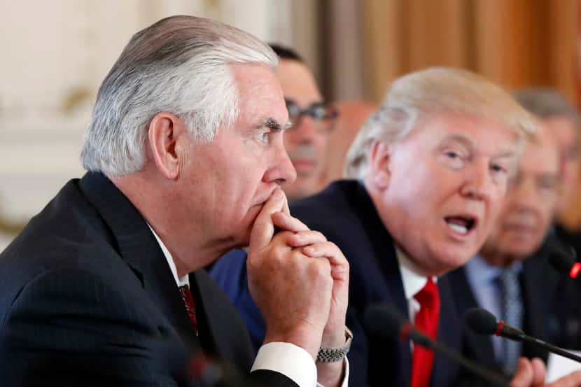 Secretary of State Rex Tillerson, left, listens as President Donald Trump speaks during a...