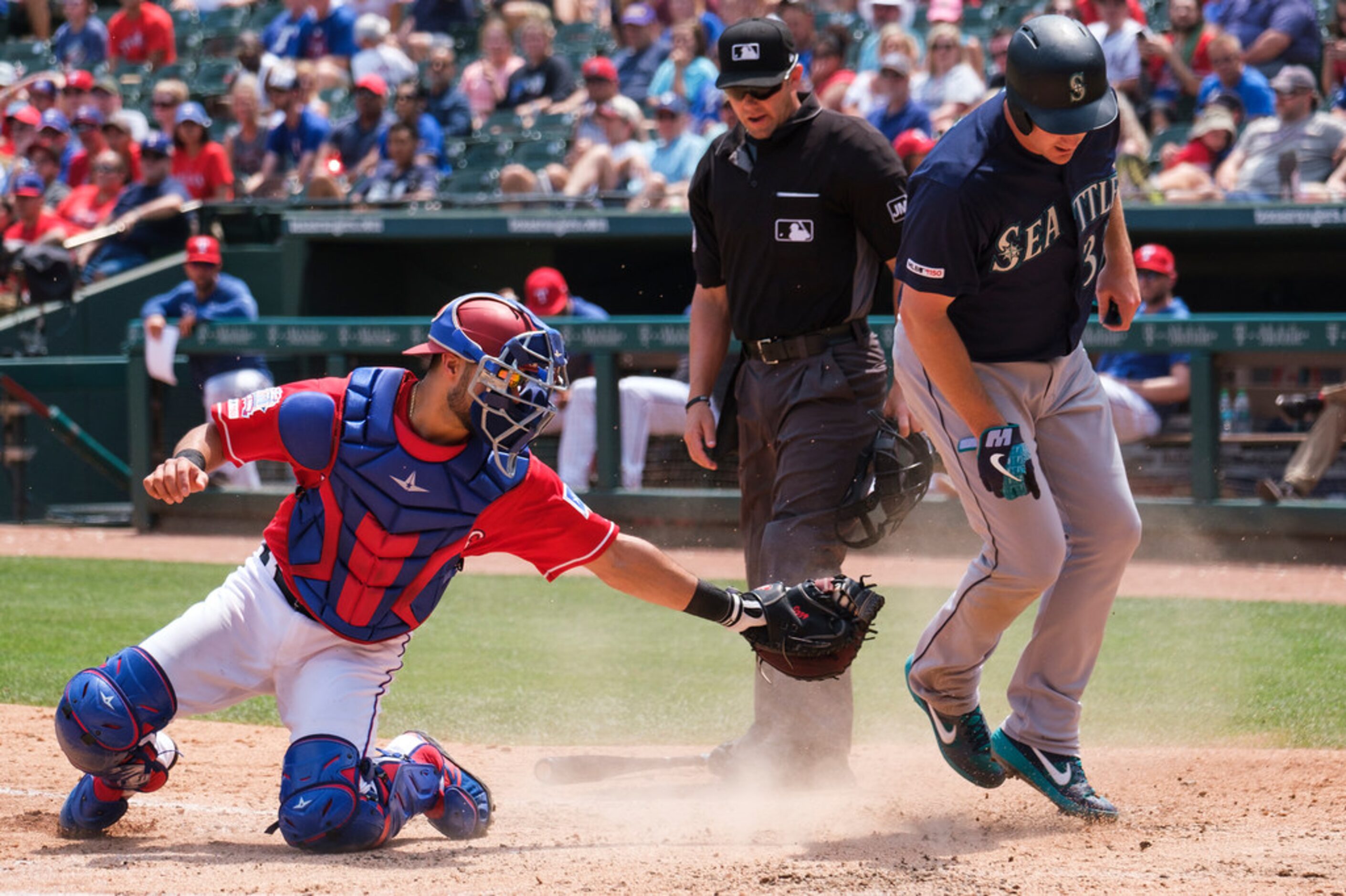 Seattle Mariners right fielder Jay Bruce scores past Texas Rangers catcher Isiah...