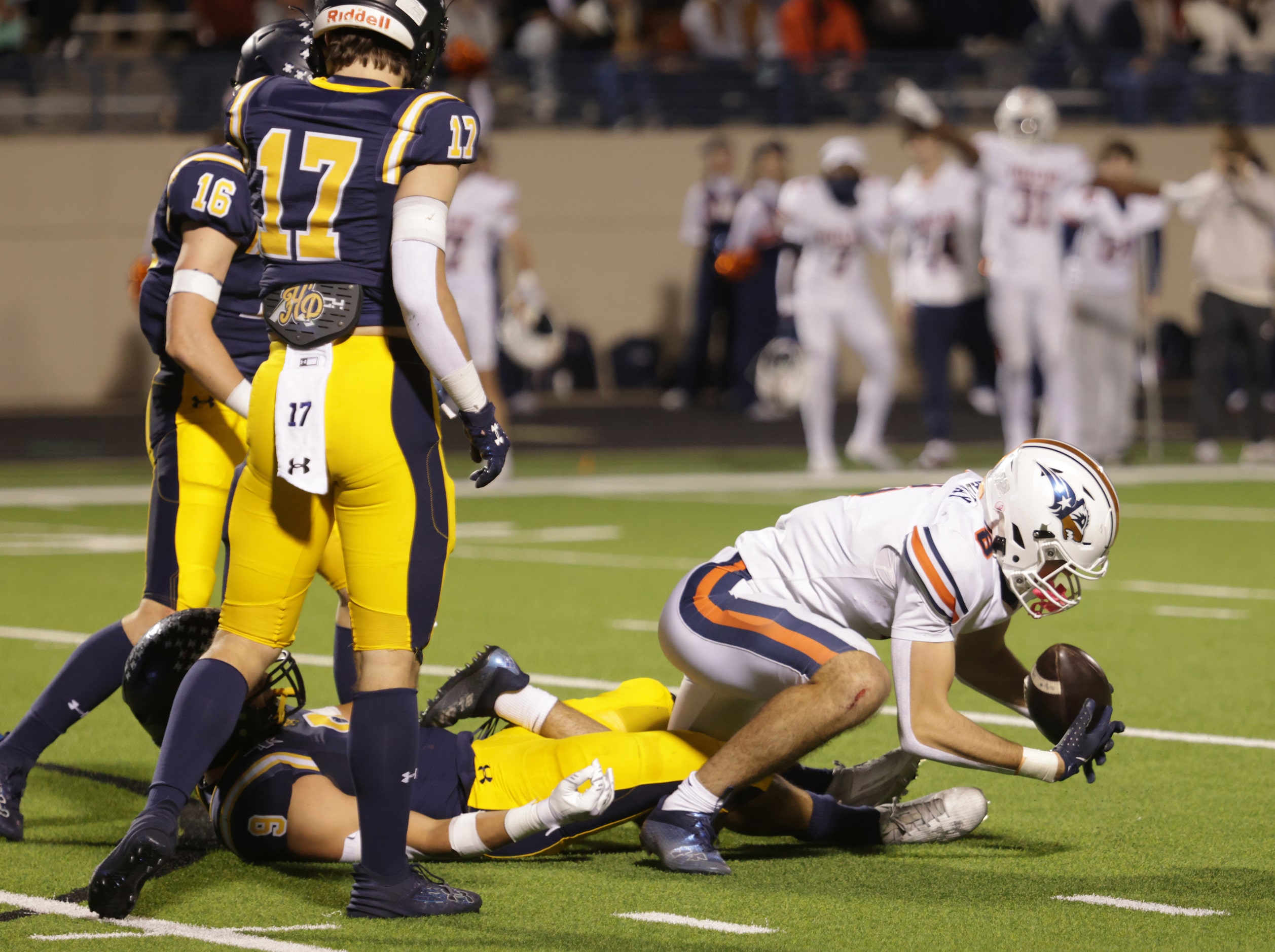 Frisco Wakeland's Ryder Treadway tries to gain control of the ball in a football playoff...