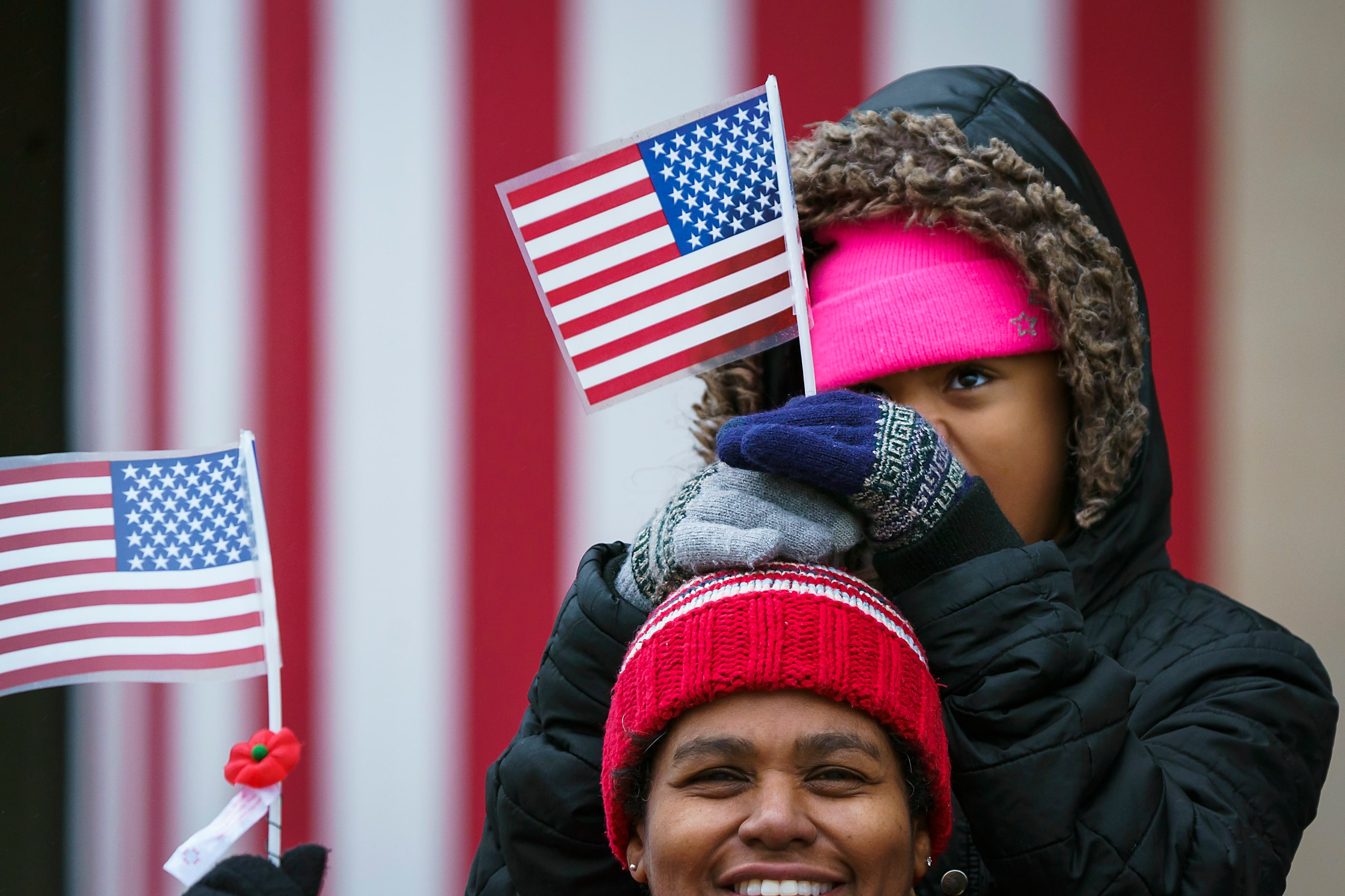 Christina Michell-Ortega, 10, holds a flag atop the head of her mother Maria Ortega of...