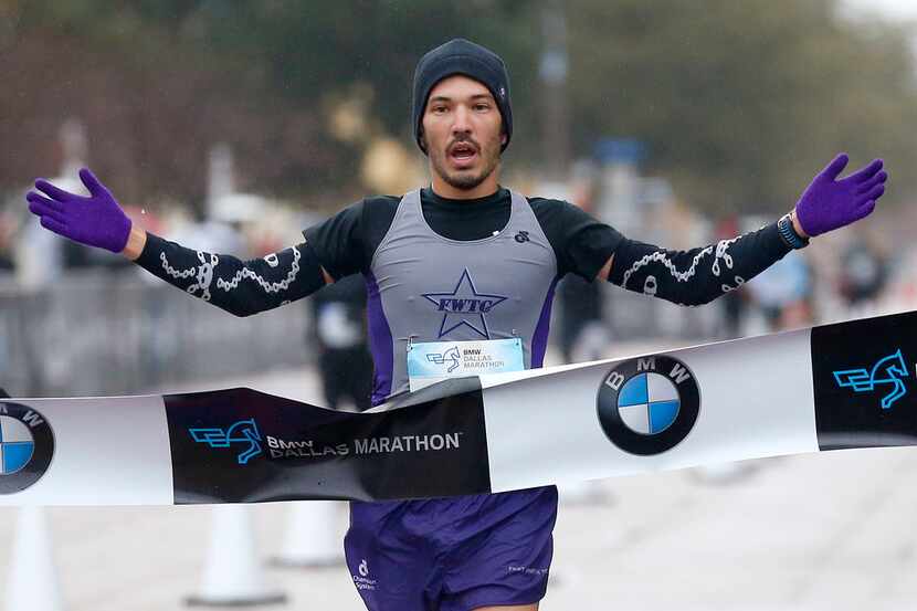 Runner Keith Kotar of Aledo, Texas crosses the finish line, winning the BMW Dallas Marathon...
