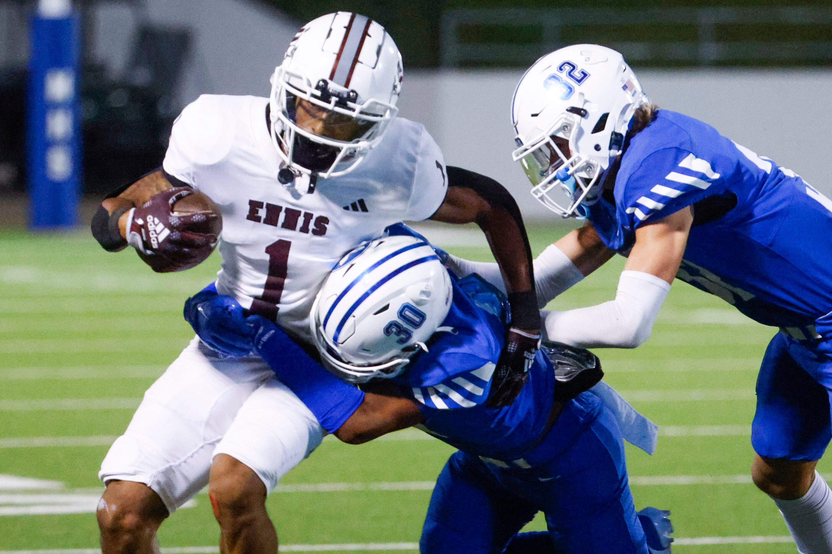 Ennis’ QB Wondame Davis Jr. (1) gets tackled by Midlothian’s Conlin Johnson (center) and...