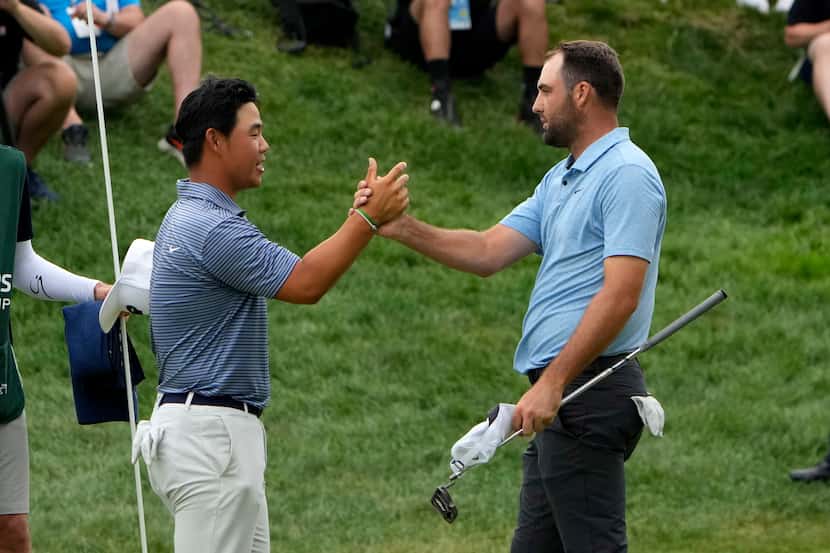 Scottie Scheffler, right, shakes hands with Tom Kim, of South Korea, after winning the...