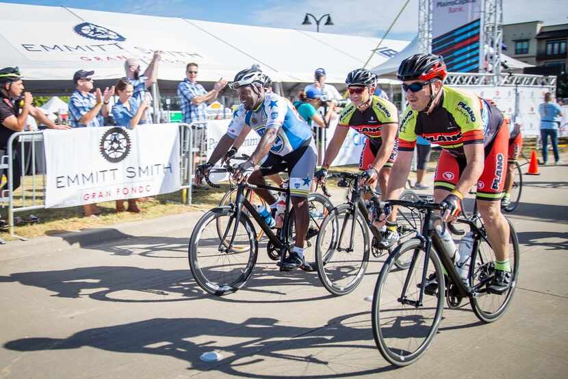 Former Dallas Cowboy Emmitt Smith crosses the finish line after riding 45 miles in his...