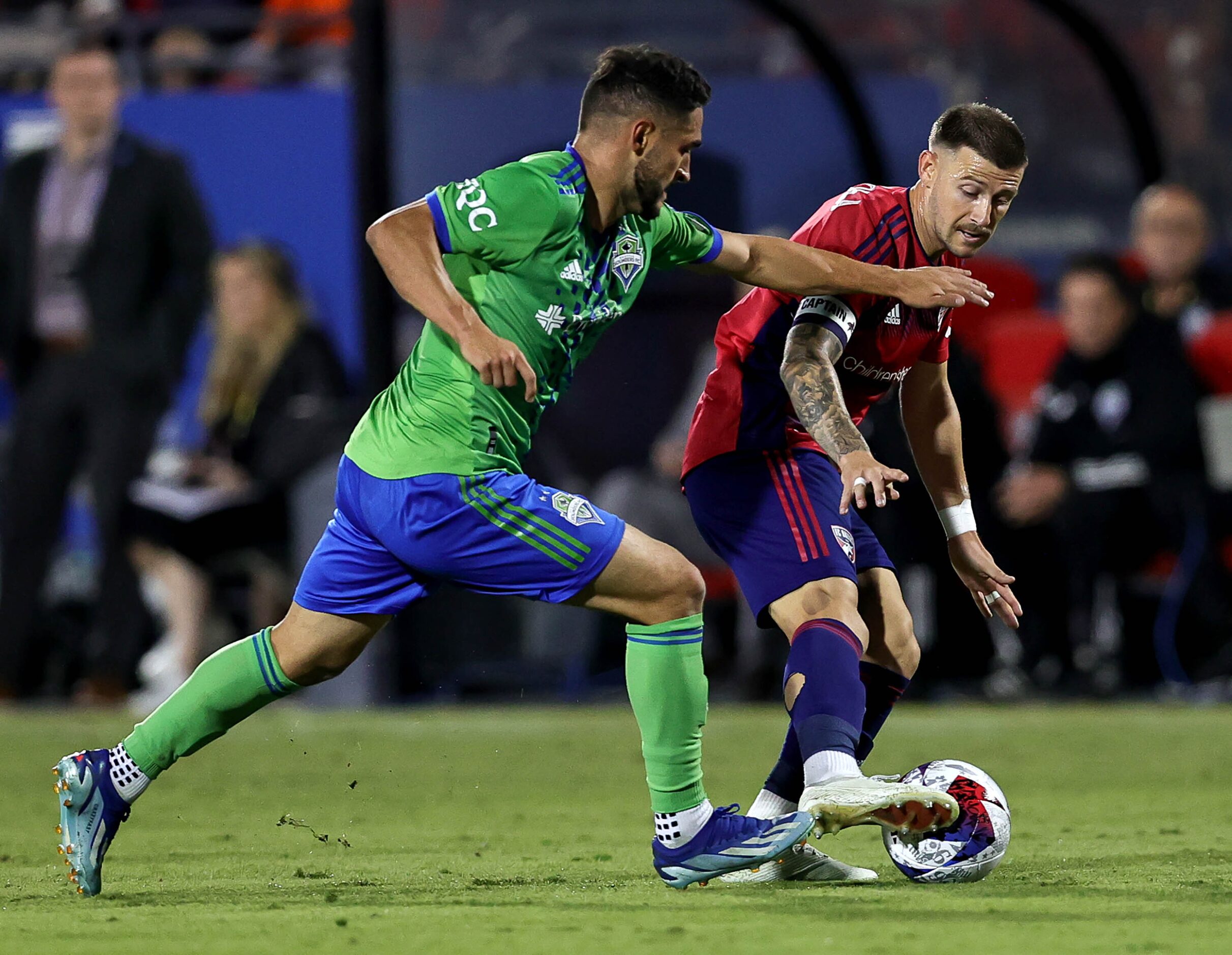 FC Dallas attacker Paul Arriola (right) tries to keep the ball away from Seattle midfielder...