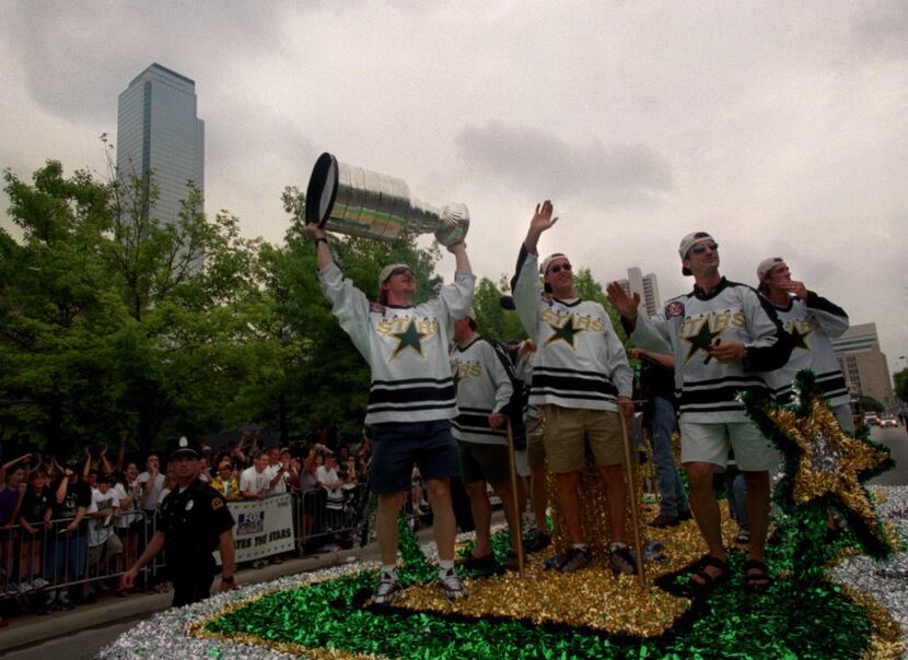 Mike Keane shows off the Stanley Cup as the parade makes its way down Young Street in...
