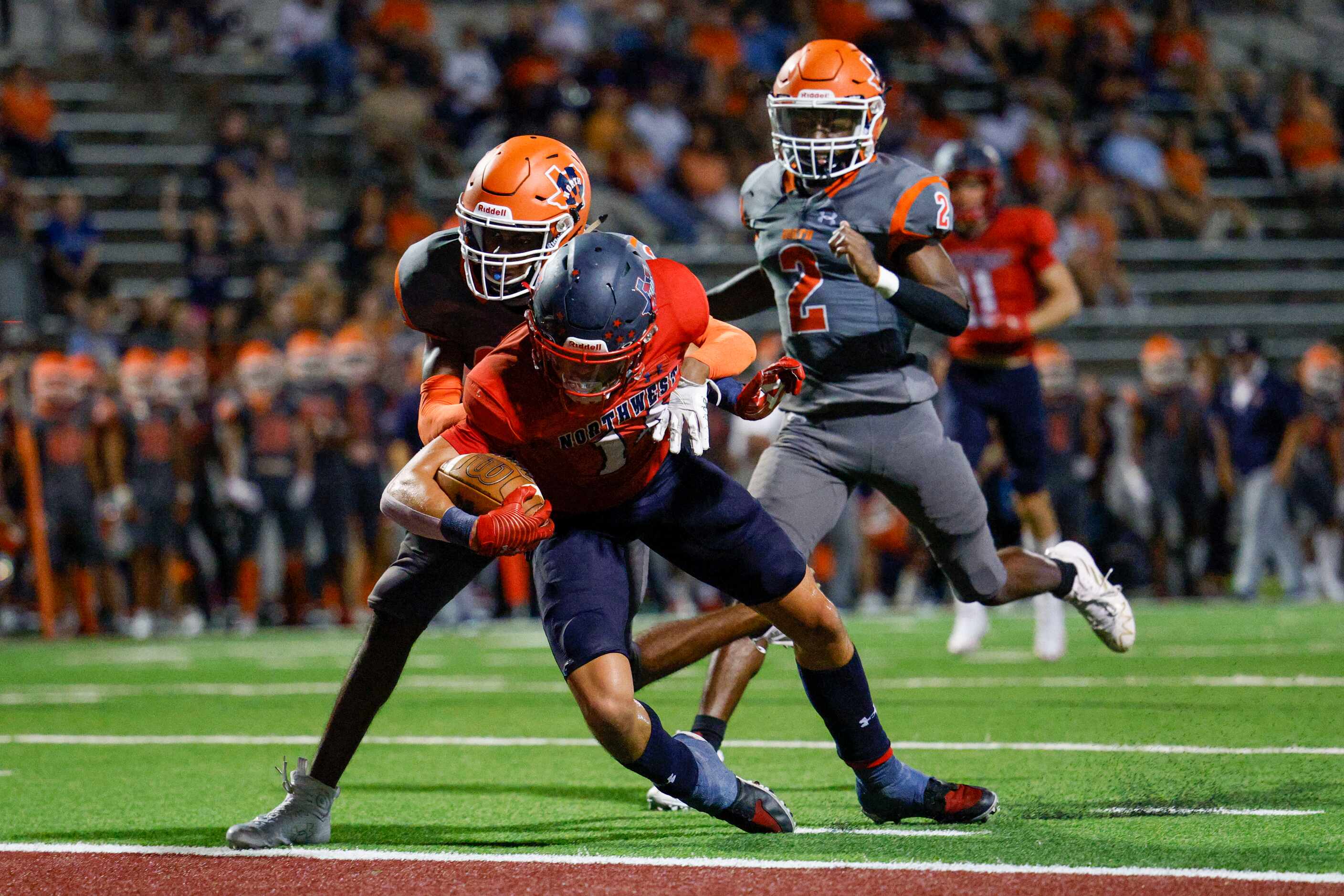 McKinney North cornerback David Walker (22) tackles Justin Northwest wide receiver Logan...