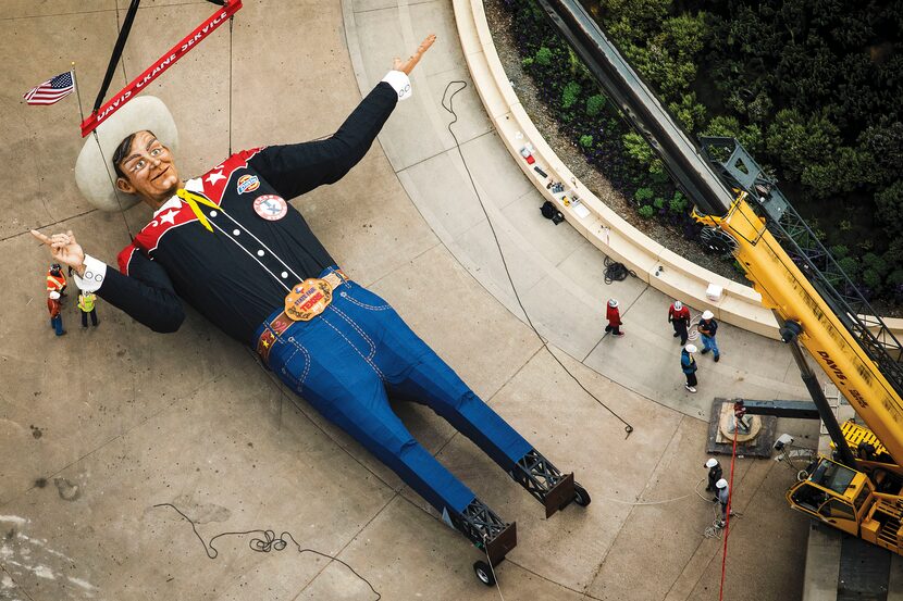 Howdy, folks! With the help of a crane, workers prepare to get Big Tex on his feet and into...