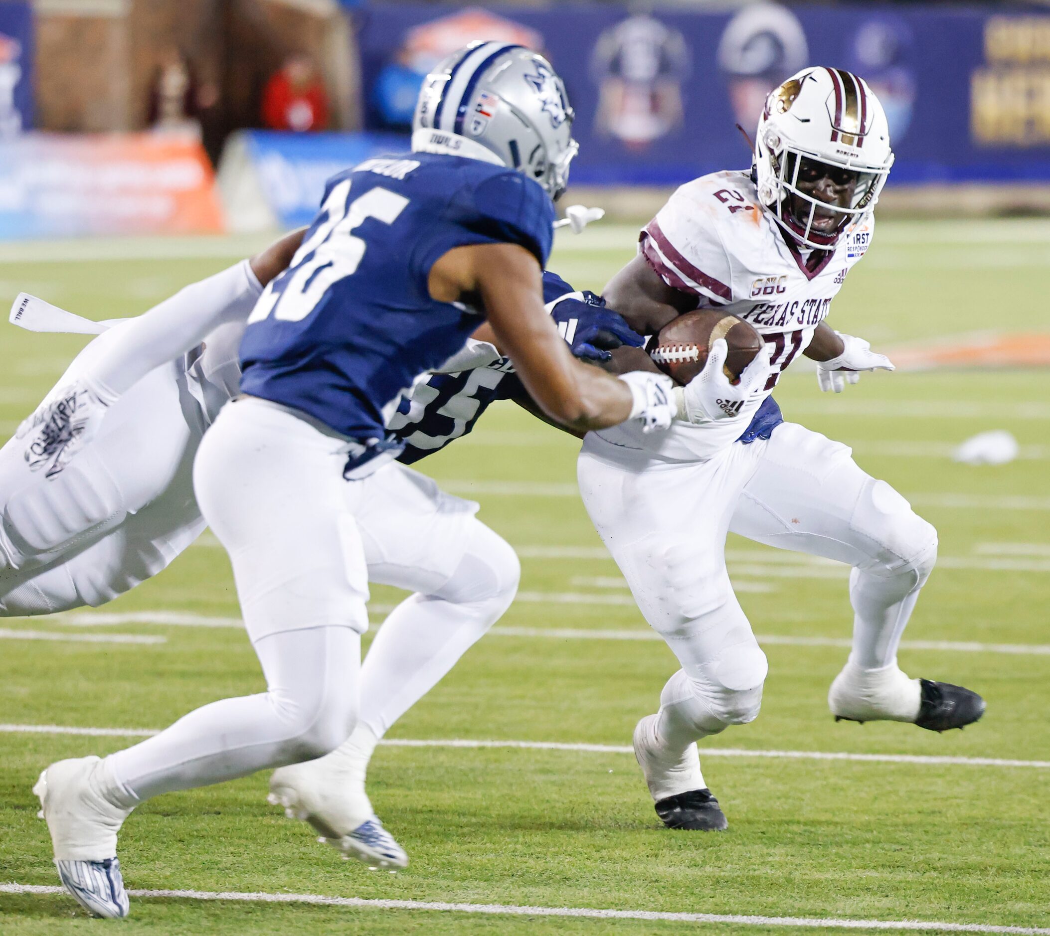 Texas State running back Ismail Mahdi (right) looks to run past Rice safety Gabriel Taylor...