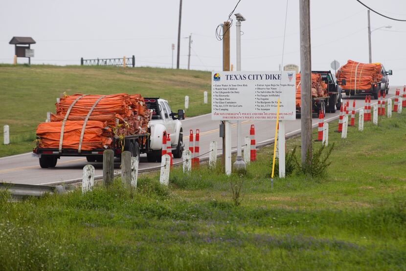 Environmental personnel drive onto the Texas City Dike with oil containment booms for oil...