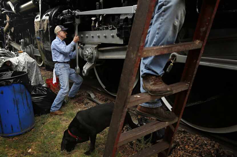 Bruce Parent (left) works at cleaning the crossheads of Union Pacific Steam Locomotive No....