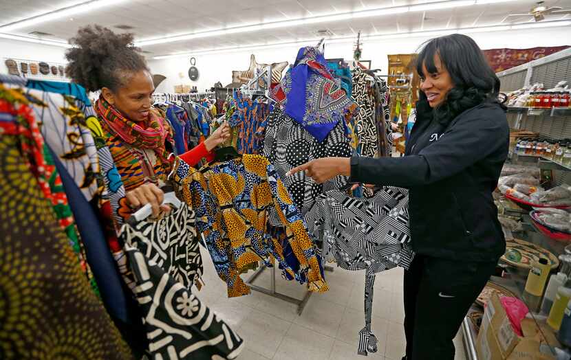 Owner Akwete Tyehimba (left) shows regular customer Nia Khepera some dresses.