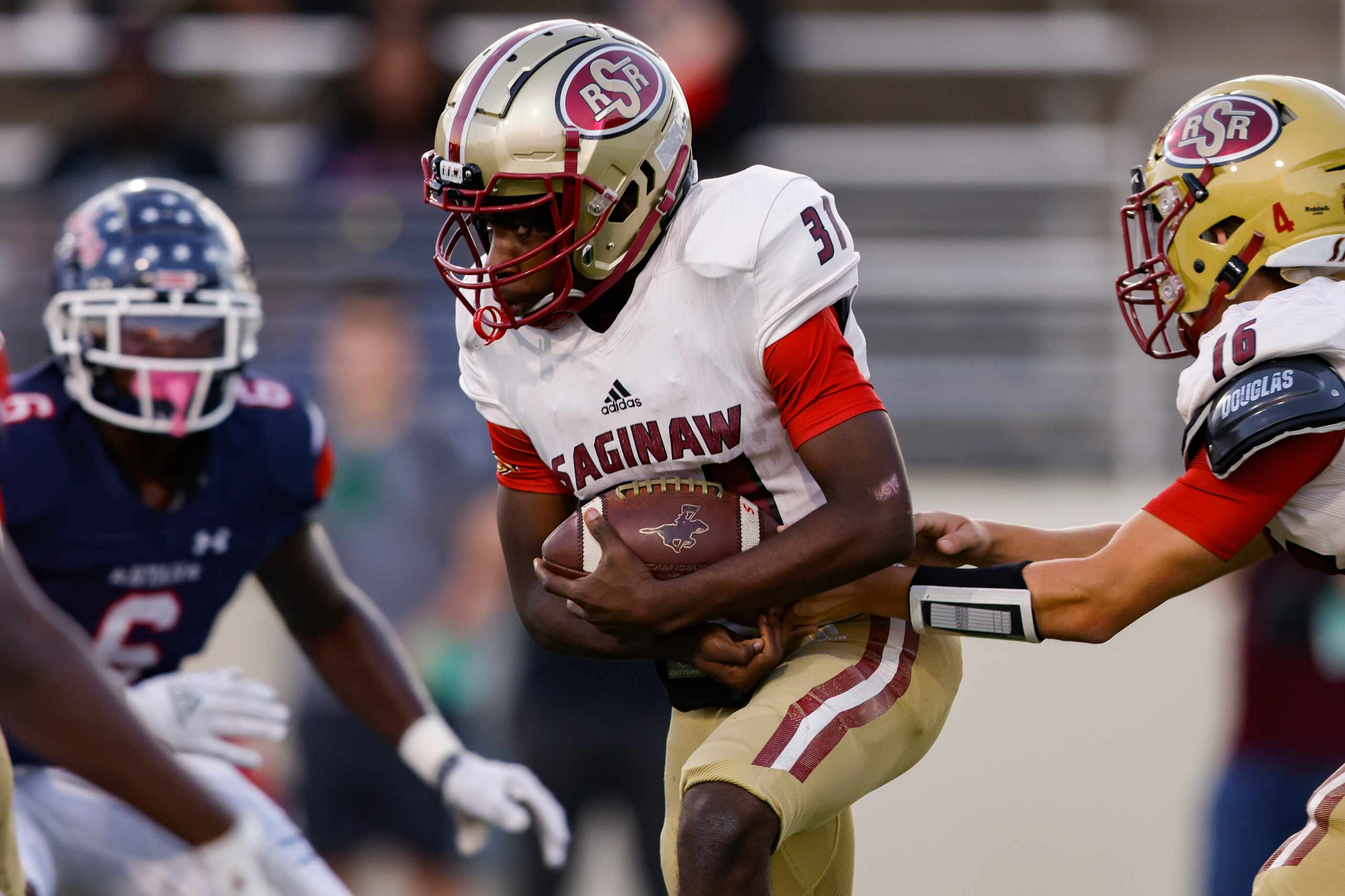 Saginaw’s running back Don’na Wren (31) is handed the ball by quarterback Giovanni Petrella...