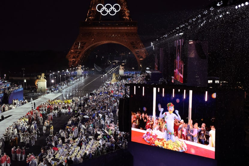 Delegations arrive at the Trocadero as spectators watch French singer Philippe Katerine...