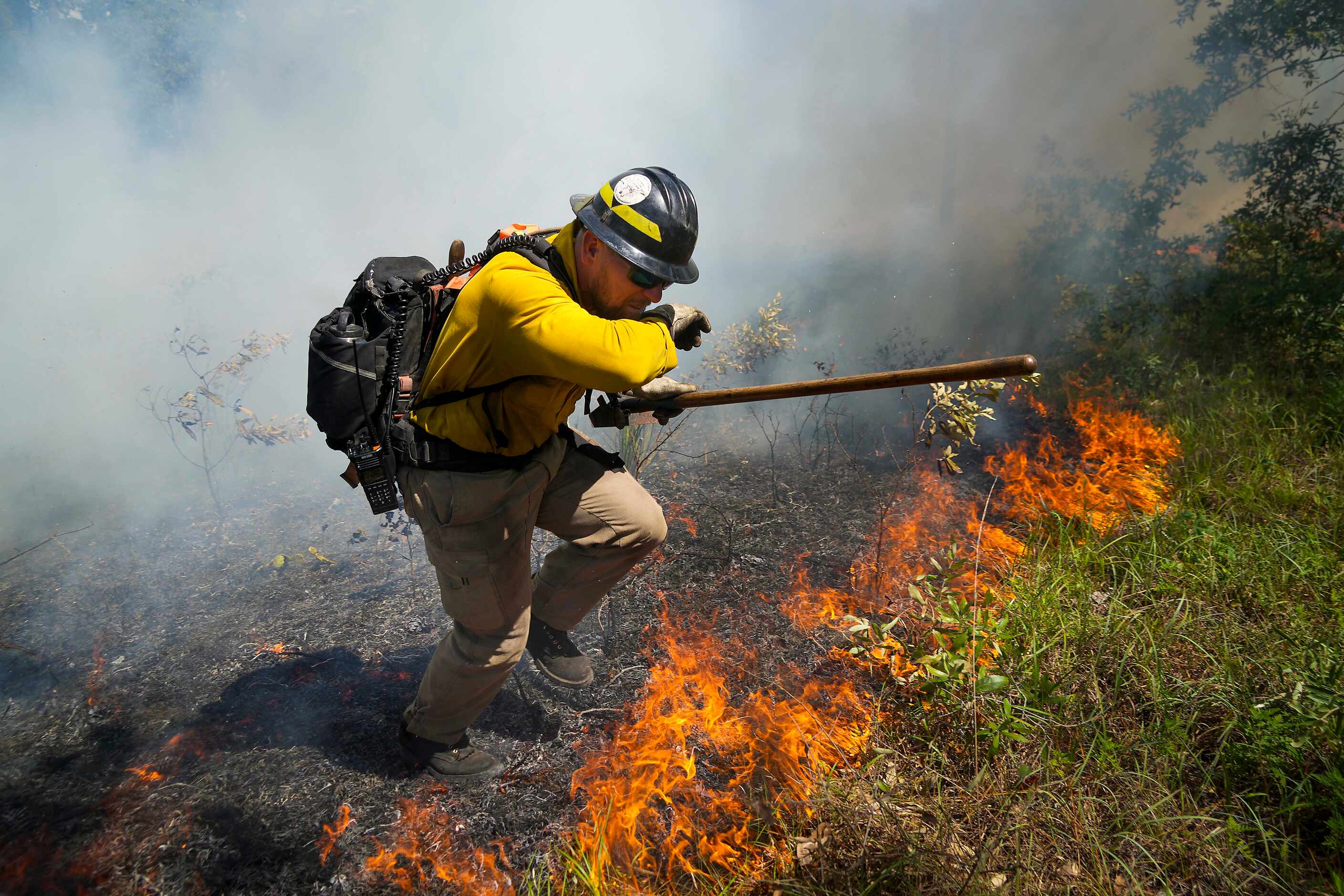 Ronald Deroche of US Fish and Wildlife Service crosses a fire line during a prescribed burn...