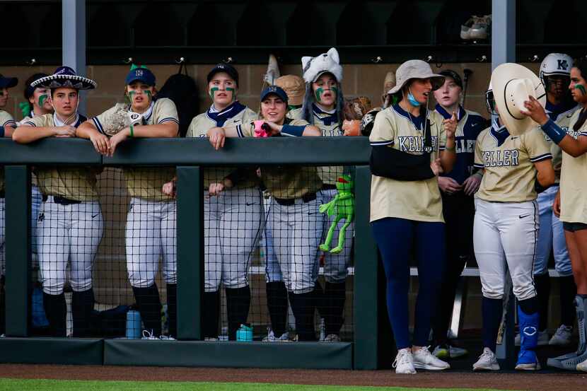 Keller players wear random hats on the sideline of a nondistrict softball game against...