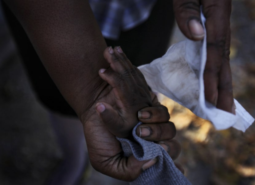 Sha-Londa Shanks uses a wet-wipe to clean the hands of her son, D'Shaun, 2,  following...