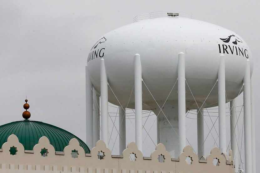 A water tower with the City of Irving logo looms over the Islamic Center of Irving at 2555...