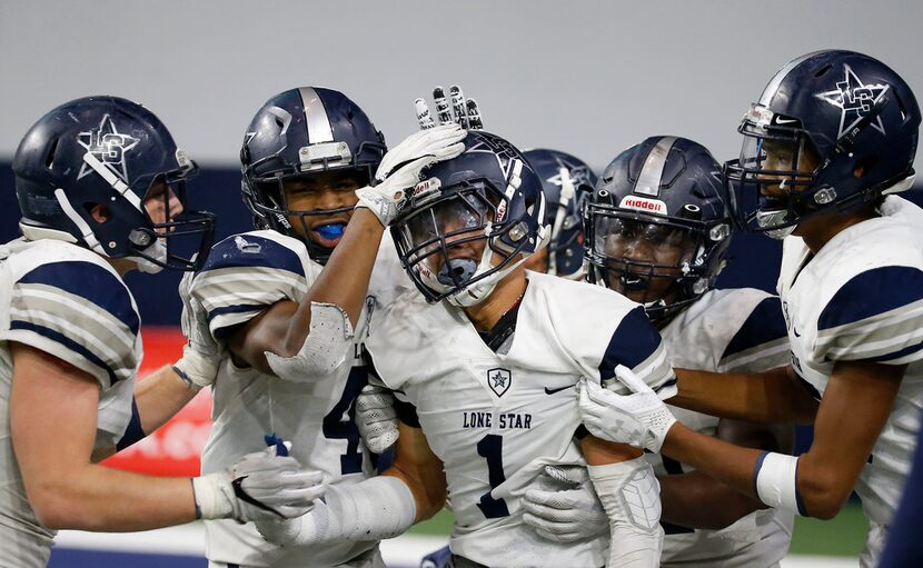 Frisco Lone Star's Nick Kitchens (1) is congratulated by his teammates after he intercepts a...