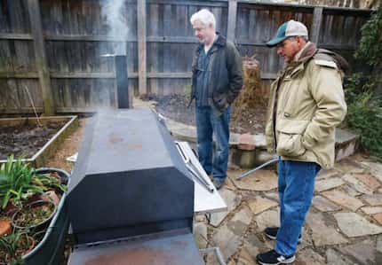 Mark Vamos (left) and Cattleack Barbeque pitmaster Todd David tend the smoker in Vamos'...