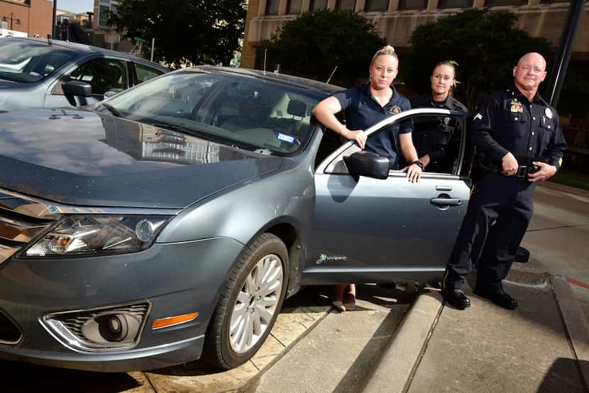 L-R: Dallas Police Officers with the Mobile Surveillance Unit, Manager Emily Davis, left,...