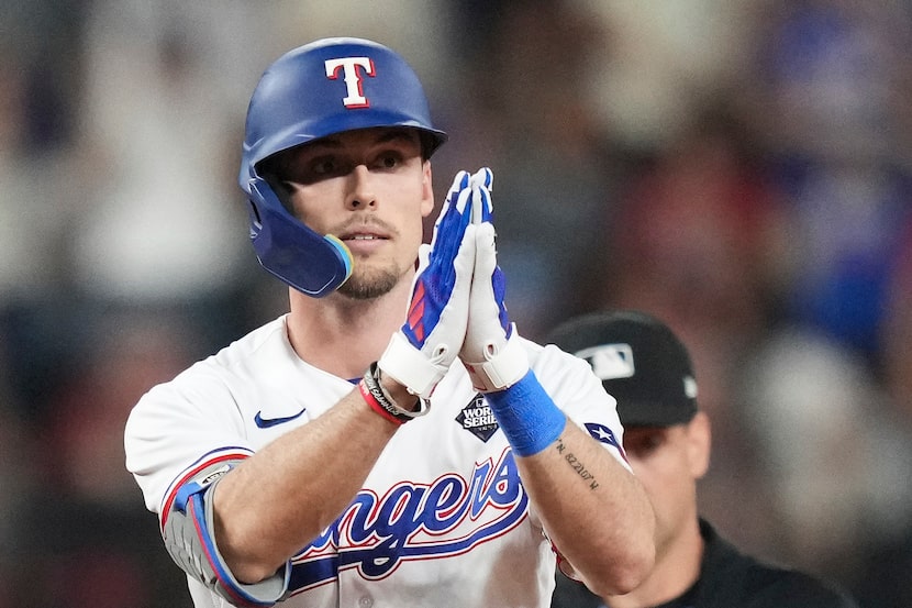 Texas Rangers' Evan Carter celebrates after hitting a double during the third inning in Game...