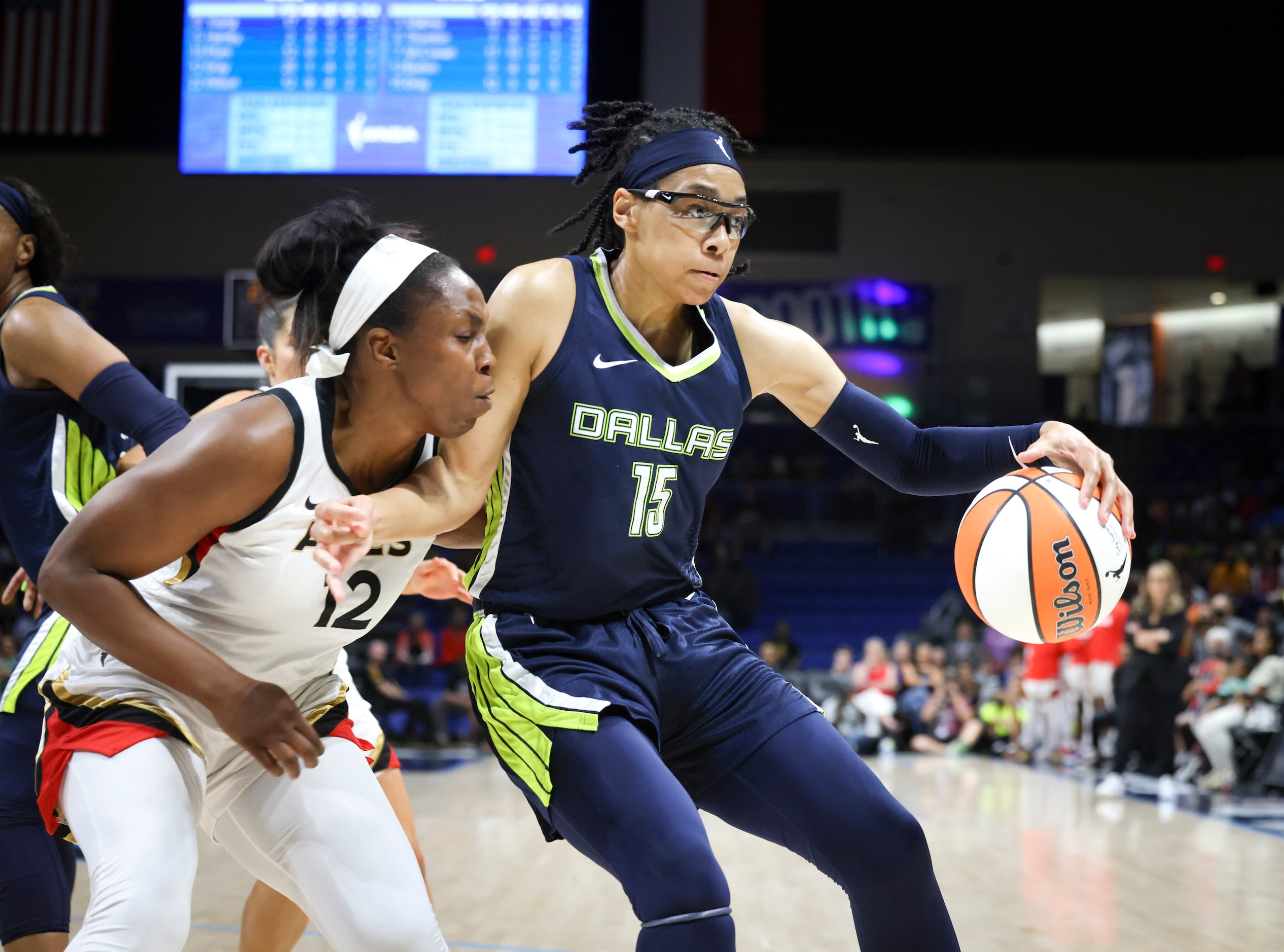 Las Vegas Aces guard Chelsea Gray (12) defends Dallas Wings guard Allisha Gray (15) as she...