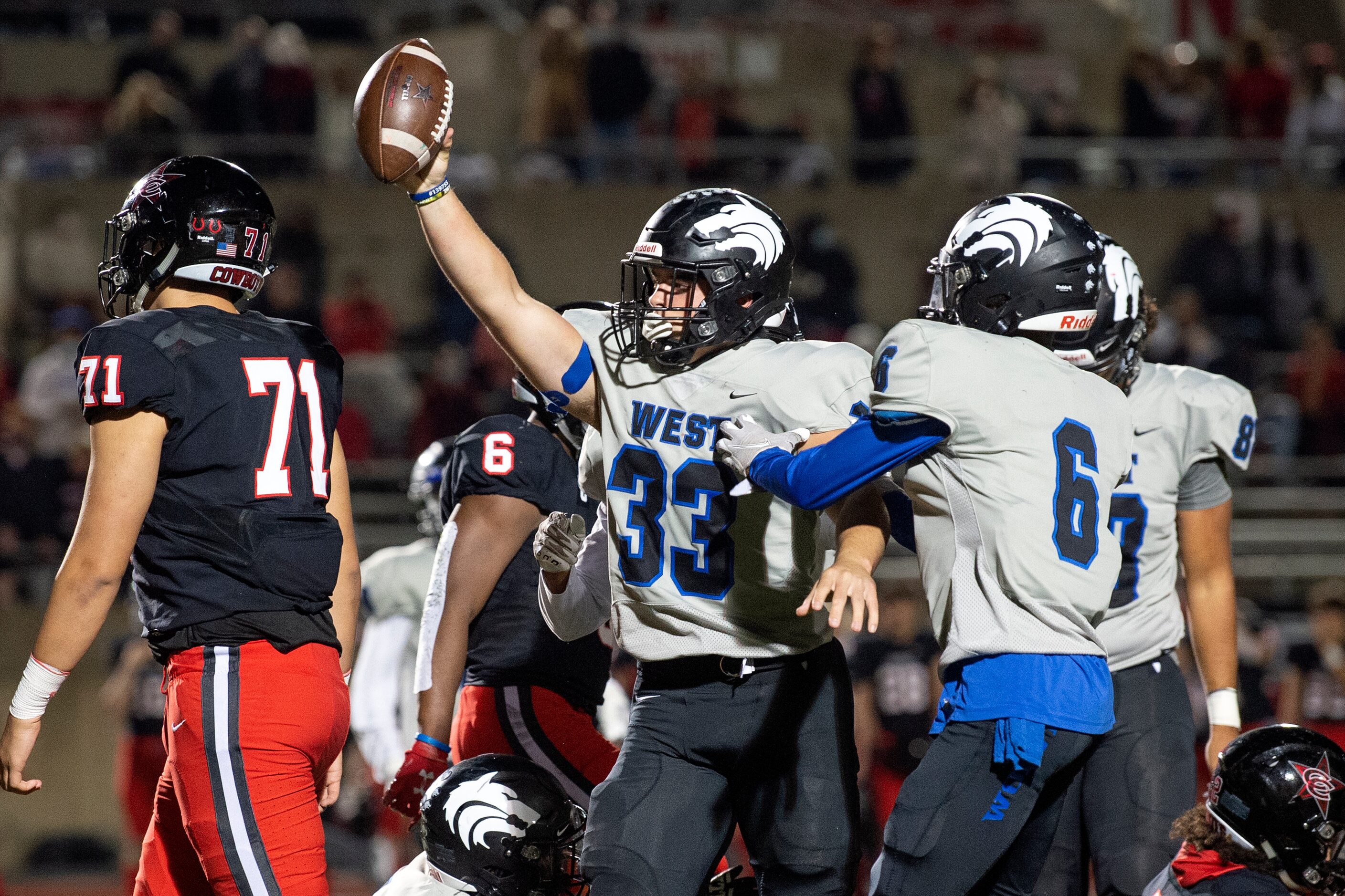 Plano West senior defensive end Cole Frederick (33) celebrates a fumble recovery with senior...