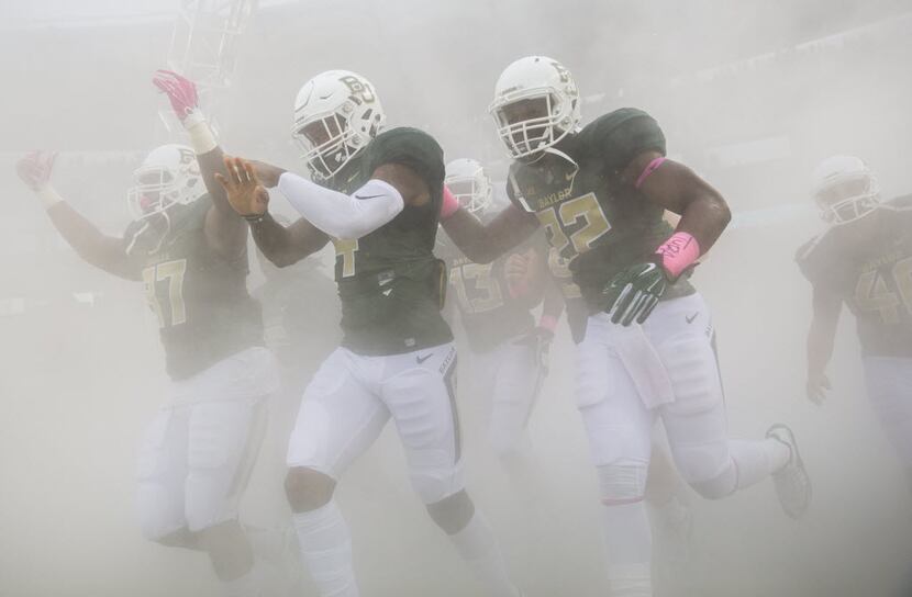 The Baylor Bears enter the field through a cloud of smoke before their game against the Iowa...