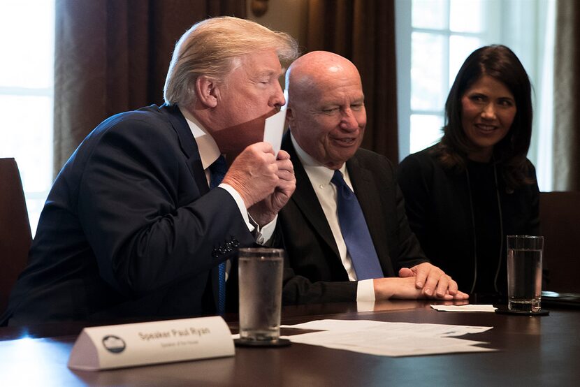 President Donald Trump kisses a  "postcard" tax return, part of the outline of the...