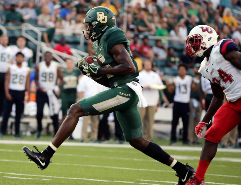 Baylor wide receiver Denzel Mims, left, pulls in a touchdown over Liberty cornerback Malik...