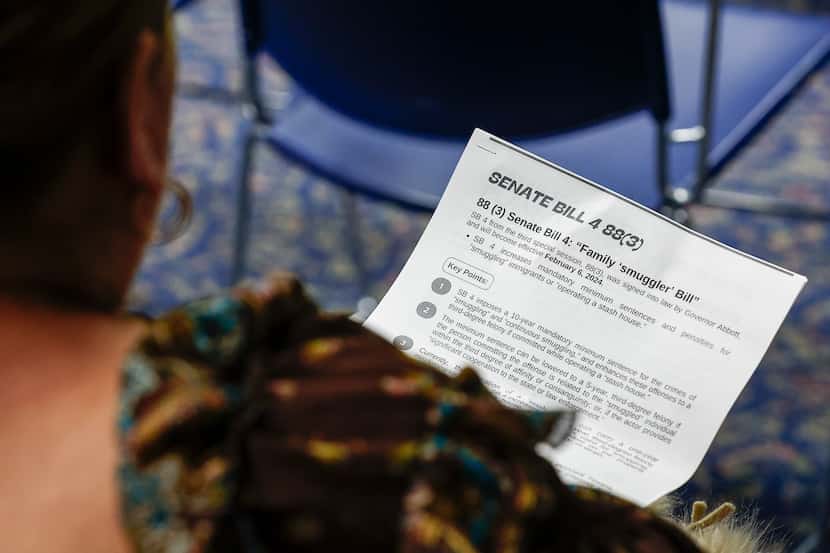 An attendee of Texas State Representative Ana-Maria Ramos’ town hall meeting reads a flyer...