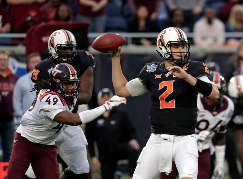 Oklahoma State quarterback Mason Rudolph (2) throws a pass as he is pressured by Virginia...