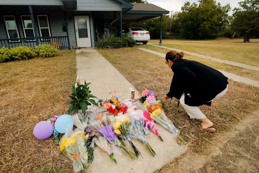 Anastasia Gonzalez of Burleson leaves flowers on the sidewalk in front of Atatiana...