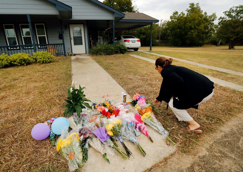 Anastasia Gonzalez of Burleson leaves flowers on the front sidewalk of Atatiana Jefferson's...