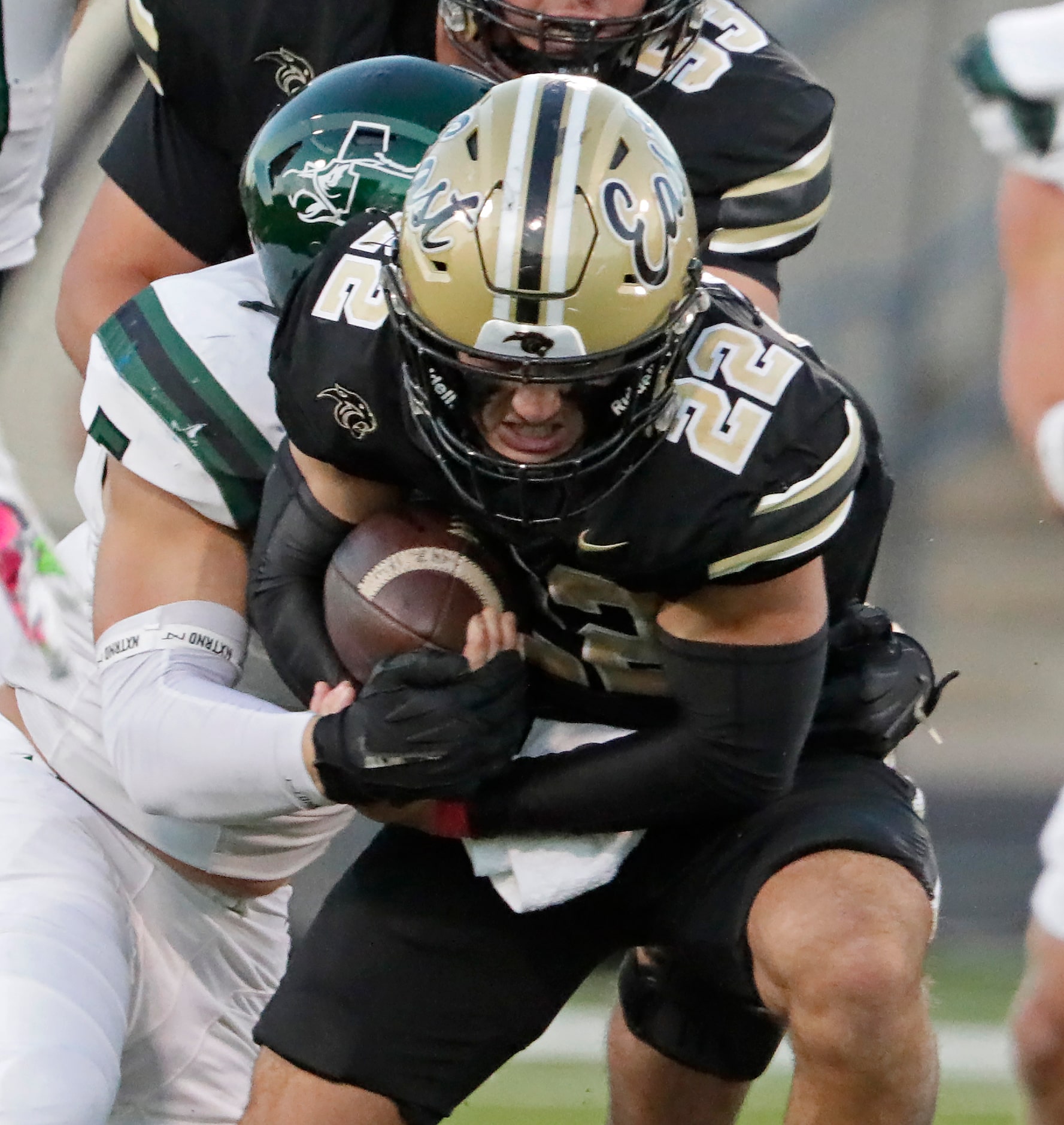 Plano East High School running back Travis Agee (22) is wrapped up during the first half as...