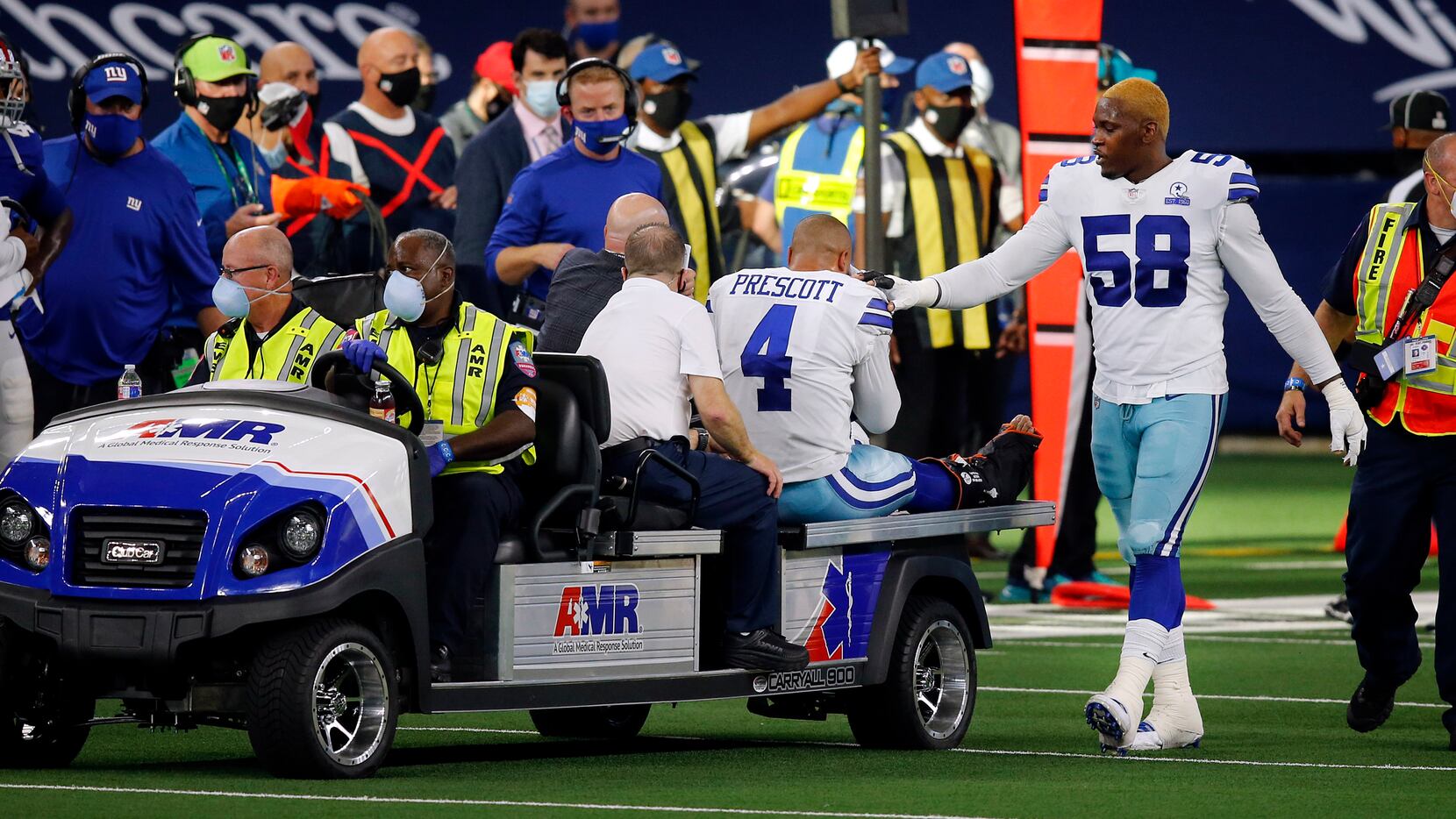 Dallas Cowboys defensive end Aldon Smith (58) comforts quarterback Dak Prescott (4) as he's...