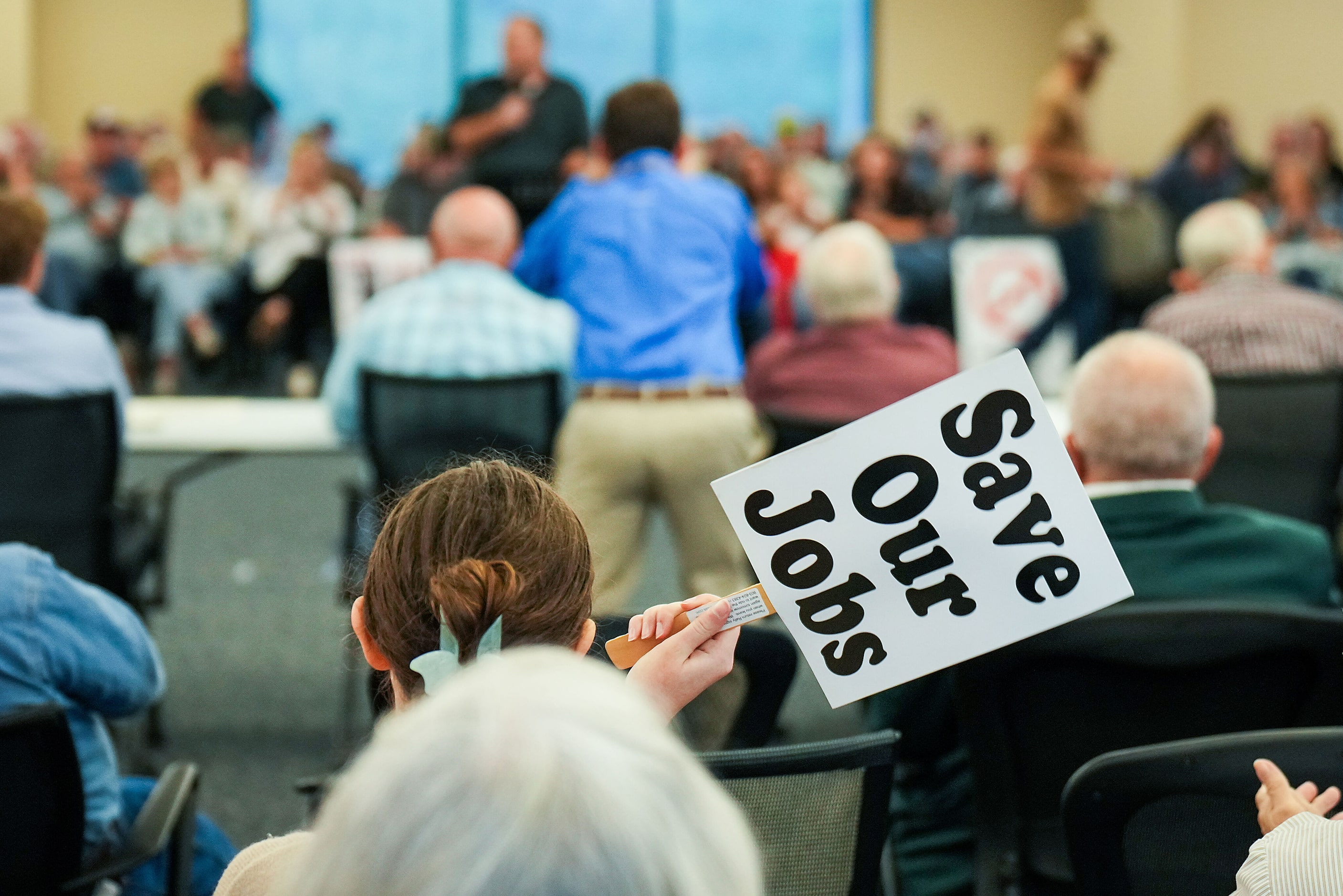 Opponents hold signs in opposition to the proposed Marvin Nichols Reservoir during a meeting...