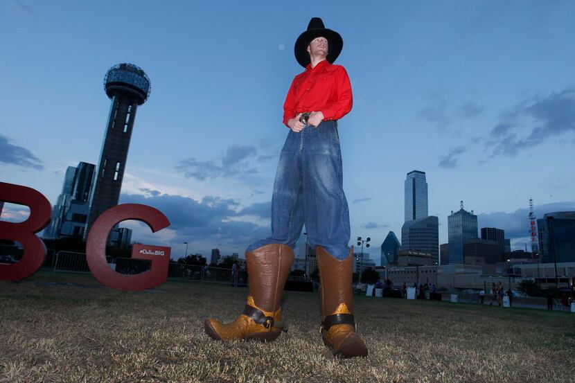 Anthony Ybarra tall as he poses with Reunion Tower in the background.