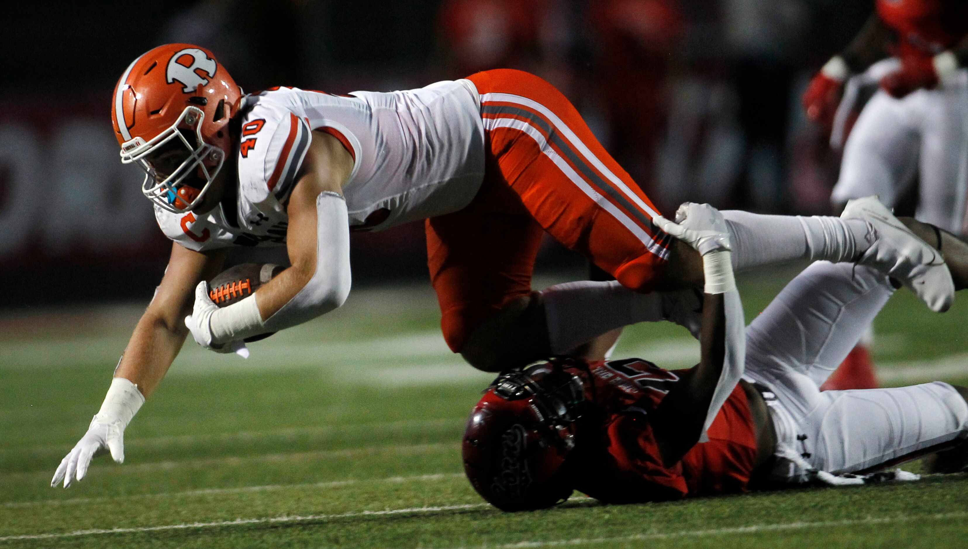 Rockwall tight end Brennan Ray (40) dives for extra yardage as he is tackled by Cedar Hill...
