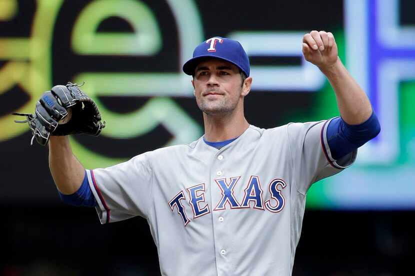 Texas Rangers starting pitcher Cole Hamels stretches after giving up a walk to the Seattle...