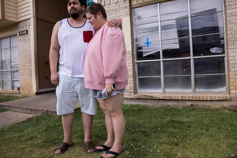 Daniel Aguilar and his wife, Kayla Aguilar, wait outside their apartment as crime scene...